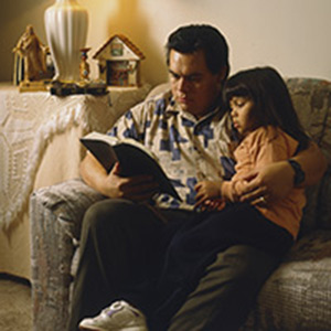 Un hombre y una niña leyendo las Escrituras