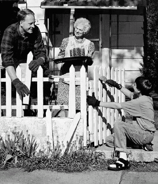 man and boy fixing older woman's fence