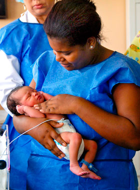 Eine Frau hält einen Säugling im Arm
