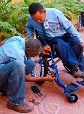 Ein Mann repariert einen Rollstuhl