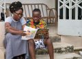 迦納的一對母子閱讀利阿賀拿。
