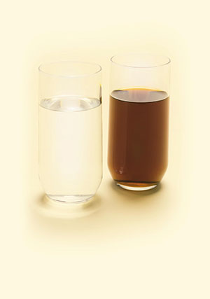 two glasses, one containing clean water and one containing dirty water