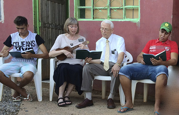 senior missionary couple with young women