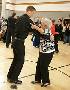 young man and old woman dancing