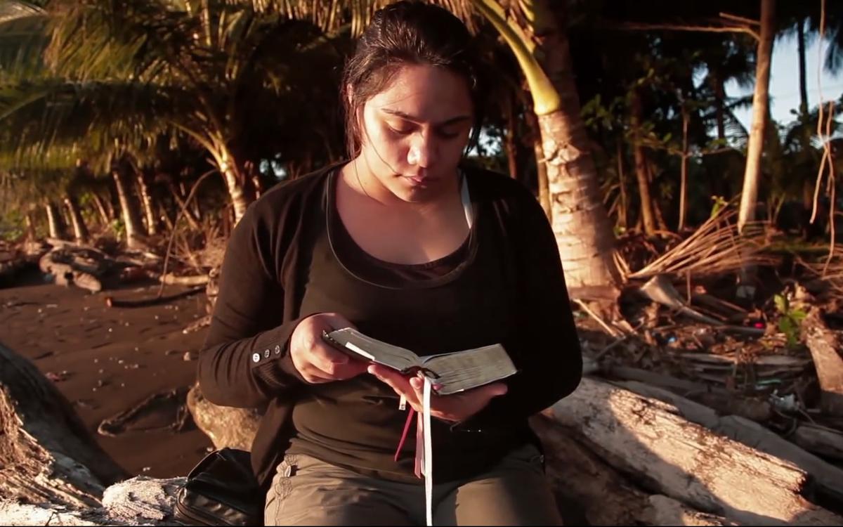 Eine junge Frau liest in den heiligen Schriften