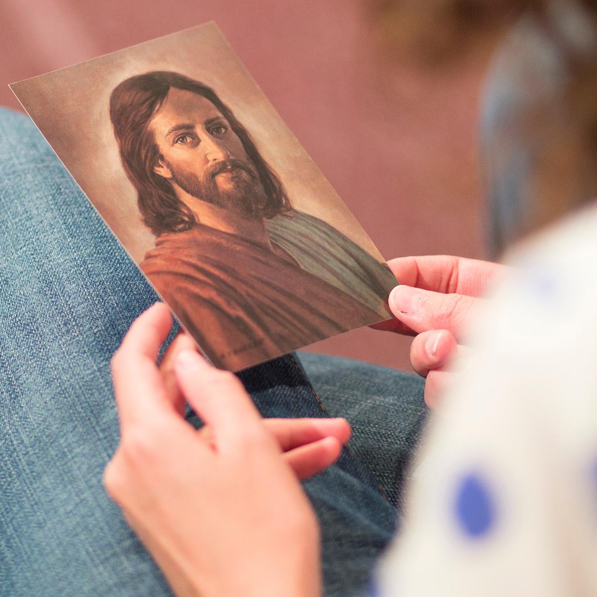 Mujer joven mirando la ilustración de Cristo